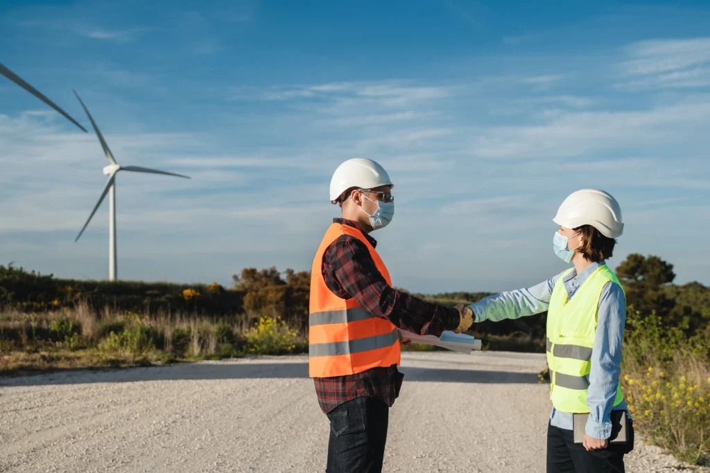 Equipo de trabajo especializado en consultoría ambiental conversa sobre el diseño e impacto de un parque eólico como parte de un proyecto de energía limpia sustentable.