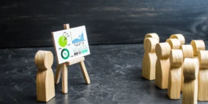 Un grupo de figuras observa una presentación con símbolos relacionados con los ODS, lo que sugiere un entorno educativo o de concientización.